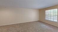 Located at 13731 Goldmark Dr in Dallas, TX, this single-floor, 2-bedroom, 2-bathroom residence offers a practical and comfortable layout designed for everyday living. The living room serves as the heart of the home, featuring warm neutral-toned walls, plush carpeting, and a front door flanked by windows that invite abundant natural light. A built-in arched shelving unit adds a decorative touch near the entryway, while an adjacent kitchen pass-through with dark wood cabinetry provides a connected, open feel. Each bedroom is carpeted and finished in light, neutral tones, with one bedroom featuring a large window with outdoor views and a ceiling fan with light fixture for added comfort. Both bedrooms are supported by dedicated closets, including a spacious walk-in closet with wire shelving that maximizes storage capacity. The two bathrooms are functional and clean; one includes hardwood-style flooring, a wood-toned vanity with a broad countertop and large mirror, and a tub-shower combination with white tile surround. A connecting hallway ties the layout together efficiently. Throughout the residence, consistent neutral color palettes, carpeted bedrooms, and warm wood-toned accents create a cohesive and inviting atmosphere.