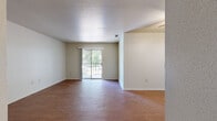 This single-floor residence offers a practical and comfortable layout designed to maximize open living space. The main living area is spacious and bright, featuring warm wood-style flooring that extends throughout the common areas, neutral-toned walls, and a textured ceiling. A sliding glass door floods the room with natural light and opens to a private balcony, offering pleasant views of surrounding greenery.

The kitchen is positioned adjacent to the living area and is accessible via a half-wall pass-through counter, creating an open and connected feel. It is equipped with warm wood cabinetry, a double-basin stainless steel sink, light countertops, and a full-size black refrigerator, providing functional storage and prep space.

The bedroom is generously sized and features plush carpeting, a ceiling fan with light fixture, and a window that allows for additional natural light. The bathroom includes a wood-toned vanity with a wide countertop, an integrated sink, a large mirror, and a separate tub-shower combination enclosed in clean white tile.

A ceiling fan is also present in the dining area near the kitchen, enhancing airflow throughout the space. The overall ambiance is clean, neutral, and move-in ready, offering a solid foundation for comfortable everyday living.