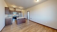 Located in Olympia, WA, this 2-bedroom, 1-bathroom unit offers a well-designed single-floor layout with a cohesive blend of modern finishes and functional living spaces. The kitchen serves as the centerpiece, featuring rich dark wood cabinetry, light stone-look countertops, a mosaic tile backsplash, and a full suite of stainless steel appliances including a refrigerator, electric range, microwave, and dishwasher. A kitchen island provides additional prep and seating space, while durable wood-look plank flooring extends through the kitchen and main living area, adding warmth throughout. Both bedrooms are carpeted and finished with neutral walls and dark wood baseboards. The primary bedroom is generously sized and connects to a dedicated walk-in closet equipped with wire shelving for organized storage. The second bedroom benefits from a large window that fills the room with natural light and offers views of the surrounding neighborhood and mature trees. The shared bathroom includes a single vanity with stone-look countertops, dark wood cabinetry, a lighted mirror, mosaic tile accents, and a full soaking tub with shower. The overall aesthetic is clean and contemporary, making this a practical and comfortable residence in the heart of Olympia.