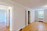 Located at 188 Bellevue Avenue in Montclair, NJ, this single-floor residence offers three bedrooms and two bathrooms within a well-organized layout. Warm hardwood floors and crisp crown molding are consistent throughout, lending a classic, cohesive character to the home.

The spacious primary bedroom is a standout feature, bathed in natural light from multiple windows that frame leafy, green outdoor views. It includes a built-in closet for practical storage. The additional bedrooms are similarly appointed with hardwood floors, crown molding, and windows overlooking the surrounding greenery, providing comfortable and bright spaces.

The kitchen is functional and well-equipped, featuring warm oak cabinetry, a tile backsplash, and stainless steel appliances including a gas range and over-the-range microwave. The bathrooms offer clean, neutral finishes, with one featuring a glass-enclosed tub and shower combination, a vanity with a white countertop, and a window for natural ventilation.

Two hallways connect the rooms efficiently, contributing to a smooth flow throughout the residence. Radiator heating units are present in multiple rooms, complemented by wall-mounted air conditioning units, ensuring year-round comfort. The overall ambiance is bright, neutral, and move-in ready.