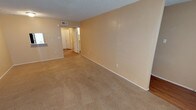 This two-story residence in Abilene is designed with a practical, straightforward layout across both levels. The living areas are finished with neutral beige carpeting and warm-toned walls, creating a cohesive and understated aesthetic throughout. Textured ceilings are a consistent feature across the space, complementing the clean white trim and baseboards found in each room.

The kitchen is efficiently arranged with ample white cabinetry providing generous storage, light-toned countertops, a stainless steel sink, and wood-look flooring. Black appliances, including a range, microwave, and dishwasher, offer a functional contrast to the light cabinetry.

The bedrooms are carpeted and include ceiling fans with light fixtures, windows dressed with blinds that allow natural light to filter in, and closet access. One bedroom features an en-suite vanity area with a framed mirror, a well-lit vanity light fixture, and a granite-style countertop, with an adjoining bathroom that includes a tub-shower combination.

Hallways throughout the space are finished with wood-look flooring and lead to additional rooms and a walk-in closet with built-in shelving, adding practical storage options to the overall layout.