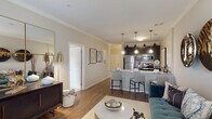 This thoughtfully designed single-floor residence offers a seamless blend of modern style and functional living. The open-concept layout connects the living, dining, and kitchen areas, creating an inviting flow throughout the space. Rich hardwood-style flooring runs through the main living areas, complemented by neutral-toned walls and elegant crown molding that add a refined architectural touch.

The kitchen is a standout feature, showcasing dark espresso cabinetry, granite countertops, a subway tile backsplash, and a full suite of stainless steel appliances. A granite-topped island with bar seating serves as both a functional workspace and a casual gathering spot, illuminated by stylish pendant lighting overhead.

The dedicated dining area offers an intimate setting, distinguished by a contemporary chandelier and crown molding details. The living room is generously proportioned and bathed in natural light from large windows with drapery accents.

The bedrooms are carpeted for comfort, with the primary bedroom featuring a ceiling fan and natural light from a window. The bathroom is finished with large-format tile flooring, a granite-topped dark vanity, and a walk-in shower, maintaining the cohesive design language found throughout the residence. Overall, the space exudes a contemporary yet welcoming ambiance.