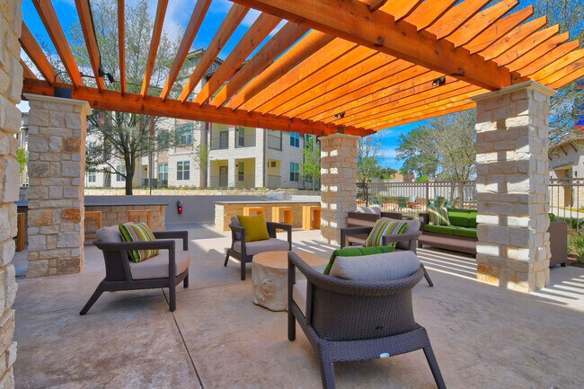 Patio al aire libre bajo pérgola y zona de parrilla en Park at Rialto Apartments, San Antonio - Park at Rialto Apartments