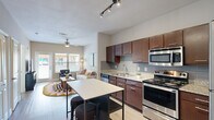 Located at 3819 Harry Wurzbach Rd in San Antonio, TX, this one-bedroom, one-bathroom residence offers a thoughtfully designed layout across a single floor. Light wood-style flooring flows seamlessly throughout the space, creating a cohesive and airy feel.

The open-concept kitchen and living area serves as the heart of the home. The kitchen is outfitted with rich dark wood cabinetry, granite countertops, a gray subway tile backsplash, and a full suite of stainless steel appliances including a gas range, microwave, refrigerator, and dishwasher. A freestanding island with a white top and integrated shelving provides additional prep space and casual seating. Track lighting overhead adds a modern touch.

The living room benefits from large windows and a glass-paneled exterior door that invite abundant natural light and views of the surrounding community. A ceiling fan enhances comfort in both the living room and bedroom.

The bedroom is a calm retreat with a window framing natural light, neutral warm-toned walls, and ample room for furnishings. An adjoining closet provides dedicated storage.

The bathroom features granite countertops, dark wood cabinetry, light wood-style flooring, a shower-tub combination, and built-in wire shelving along the wall for added organization. The clean, neutral palette ties the entire residence together cohesively.