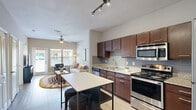 Located at 3819 Harry Wurzbach Rd in San Antonio, TX, this one-bedroom, one-bathroom residence offers a thoughtfully designed layout across a single floor. Light wood-style flooring flows seamlessly throughout the space, creating a cohesive and airy feel.

The open-concept kitchen and living area serves as the heart of the home. The kitchen is outfitted with rich dark wood cabinetry, granite countertops, a gray subway tile backsplash, and a full suite of stainless steel appliances including a gas range, microwave, refrigerator, and dishwasher. A freestanding island with a white top and integrated shelving provides additional prep space and casual seating. Track lighting overhead adds a modern touch.

The living room benefits from large windows and a glass-paneled exterior door that invite abundant natural light and views of the surrounding community. A ceiling fan enhances comfort in both the living room and bedroom.

The bedroom is a calm retreat with a window framing natural light, neutral warm-toned walls, and ample room for furnishings. An adjoining closet provides dedicated storage.

The bathroom features granite countertops, dark wood cabinetry, light wood-style flooring, a shower-tub combination, and built-in wire shelving along the wall for added organization. The clean, neutral palette ties the entire residence together cohesively.