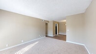 Located at 1598 Crestview Dr in Nashville, TN, this single-floor, 2-bedroom, 2-bathroom home offers a well-organized layout with a cohesive neutral color palette throughout. The spacious living room features plush carpeting, a textured ceiling, and a set of French doors that invite natural light and provide outdoor access. The layout flows naturally into the kitchen, which is designed as a galley-style space equipped with dark cabinetry, granite-look countertops, a stainless steel sink, and a classic subway tile backsplash — all set atop warm hardwood-style flooring. The primary bedroom is a generous, sunlit retreat with soft carpet, a large window offering outdoor views, and a full-wall mirrored sliding closet. The second bedroom mirrors similar finishes, with carpet, neutral walls, and a bright window. Both bathrooms maintain a consistent design language: one features a full tub-shower combo with clean white surrounds, while the other showcases a dark-cabinet vanity with a granite-look countertop, a large mirror, and hardwood-style flooring. A hallway and closet round out the floor plan, providing practical storage. The warm tan walls, textured ceilings, and consistent flooring choices create a cohesive and comfortable atmosphere throughout the home.
