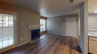 This 2-bedroom, 2-bathroom B1 floor plan is a thoughtfully designed single-level residence that balances comfort and functionality. The living room serves as the heart of the home, featuring rich, dark hardwood flooring, a tile-surround fireplace, and a large window that invites natural light throughout the space. Neutral-toned walls and a textured ceiling complement the warm aesthetic.

The open layout connects the living area to the kitchen, which is equipped with light wood cabinetry, speckled laminate countertops, and black appliances including a refrigerator, range, built-in microwave, and dishwasher. A pass-through counter enhances the sense of openness between the kitchen and main living space.

Both bedrooms are carpeted for comfort and include ceiling fans with light fixtures and generously sized windows. The primary bedroom features a spacious walk-in closet with dual hanging rods and ample shelving, providing excellent storage capacity.

Each of the two bathrooms offers a tub-shower combination with white tile surround, a vanity with granite-style countertops, and wood-look flooring. The clean, consistent finishes across both bathrooms contribute to the cohesive design of the residence. Throughout the home, the practical layout and well-maintained features make this a functional and welcoming space.