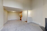 Located at 1304 Bruskrud Rd in Everett, WA, this two-story, 2-bedroom, 2-bathroom home offers a well-organized layout spread across two floors. The main floor hosts an open-concept living, dining, and kitchen area, where soft carpet flows through the living and dining spaces while warm hardwood-style flooring extends into the kitchen. The kitchen features a galley-style design with white cabinetry, gray countertops, stainless steel appliances including a refrigerator and dishwasher, and a black range — all maximizing functionality in a compact, efficient footprint. A balcony provides access to the outdoors, and baseboard heating is present throughout. A staircase connects the main floor to the upper level, where both bedrooms are located. Each bedroom is carpeted and offers closet storage, with the primary bedroom featuring two sliding-door closets and generous proportions. The two bathrooms include hardwood-style flooring and a tub-shower combination. A convenient stacked washer and dryer unit is also included within the home. With a neutral color palette, textured ceilings, and a functional two-story design, this home offers comfortable living in a practical and well-appointed layout.