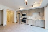 Located at 425 Centerpointe Circle in Altamonte Springs, Florida, this thoughtfully designed studio unit offers a modern aesthetic with clean lines and contemporary finishes throughout its single floor. The open-concept kitchen and living area serves as the heart of the space, showcasing floor-to-ceiling windows that flood the room with natural light and offer lush outdoor views. The kitchen is outfitted with a full suite of stainless steel appliances — including a side-by-side refrigerator, electric range, built-in microwave, and dishwasher — complemented by light wood-toned cabinetry, a linear tile backsplash, and white quartz countertops. Light-toned luxury vinyl plank flooring extends throughout, adding warmth and cohesion. The bathroom features elegant marble-style tile flooring, a wood-grain vanity with a white countertop, a large mirror, and a chrome towel bar. A dedicated closet with built-in rods provides organized storage, while a separate pantry, laundry area, and utility room add practical functionality. A ceiling fan with a modern wood-blade design anchors the living area, contributing to the overall breezy, contemporary ambiance of this well-appointed unit.