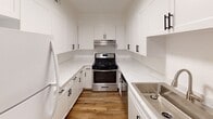Located at 4100 W 19th Ave in Stillwater, Oklahoma, this single-floor residence offers a thoughtfully updated interior with a clean, modern aesthetic throughout. Warm wood-look flooring runs consistently across the living areas, bedrooms, and hallways, creating a cohesive and inviting atmosphere.

The kitchen is a standout feature, outfitted with crisp white shaker cabinets accented by matte black hardware, marble-look quartz countertops, a stainless steel gas range, and a stainless steel sink. Ample upper and lower cabinetry provides generous storage, while the bright, well-lit layout makes the space highly functional.

The living area is open and airy, connecting seamlessly to the kitchen and featuring a distinctive exposed brick fireplace that adds character and warmth to the space. Natural light filters in through windows that offer views of surrounding greenery.

The bedroom is well-sized, equipped with a ceiling fan with light fixture and a window that brings in natural light and outdoor views. Adjacent to the bedroom is a bathroom with a vanity and sink, as well as a dedicated closet with built-in shelving for organized storage.

Throughout the unit, clean white walls, updated fixtures, and consistent flooring choices contribute to a bright, move-in-ready environment that balances comfort with contemporary style.