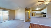 Located at 2355 Meadow Way in Santa Rosa, CA, this single-floor, 2-bedroom, 2-bathroom home offers a well-organized and functional layout. The open-concept living and kitchen area serves as the heart of the home, where warm neutral tones and a mix of hardwood and plush carpet flooring create a welcoming atmosphere. The kitchen is equipped with white cabinetry, stone-look countertops, and stainless steel appliances including a refrigerator, electric range, over-the-range microwave, and dishwasher, complemented by a peninsula that separates the kitchen from the living area. The spacious primary bedroom features a ceiling fan and a sliding glass door that opens to an outdoor balcony with views of the surrounding landscape. The second bedroom also includes a ceiling fan and a window that brings in natural light. Both bathrooms are finished with wood-look flooring, white vanities with stone-look countertops, and well-lit mirrors. The primary bathroom includes a full tub-shower combination. A hallway connects the main living spaces to the bedrooms, and three closets throughout provide ample storage. The overall ambiance is clean, bright, and move-in ready.