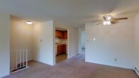 Located at 800 Kimberton Road in Phoenixville, Pennsylvania, this single-floor residence offers a straightforward and practical layout designed for comfortable everyday living. The main living area is finished with wall-to-wall carpeting underfoot, creating a warm and inviting atmosphere. A ceiling fan with integrated lighting is centrally positioned overhead, providing both air circulation and ambient illumination throughout the space. Neutral-toned walls keep the interior feeling clean and versatile, ready to accommodate a variety of décor styles. Adjacent to the living area, the kitchen is accessible through an open doorway and features warm-toned wooden cabinetry, a sink, and under-counter appliances, offering a compact yet functional cooking space. The layout flows naturally from the living area toward an additional room visible through a separate doorway, suggesting a private bedroom or utility space beyond. Baseboard heating is present along the walls, ensuring year-round comfort. The overall design is practical and well-organized, making efficient use of the available floor plan while maintaining a cohesive and livable environment throughout the residence.