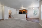 Located at 8448 W Limelight St in Boise, Idaho, this single-floor, 3-bedroom, 2-bathroom home offers a well-designed layout with comfortable living spaces throughout. The open-concept living and dining area flows seamlessly into the kitchen, which features warm wood cabinetry, dark granite countertops, a peninsula with an integrated sink, and black appliances including a refrigerator, range, and built-in microwave. A decorative chandelier and textured ceiling add character to the shared living space, which is bathed in natural light from multiple windows overlooking the outdoors. Soft carpeting covers the living and bedroom areas, while the kitchen and bathrooms feature hardwood-style flooring. The primary bedroom is a generously sized retreat with a large window and ample closet space. Two additional bedrooms offer similar comfort with natural light and carpeted floors. The bathrooms are well-appointed, featuring wood-toned vanities with stone-look countertops, modern light fixtures, and mirrored medicine cabinets. A dedicated laundry area adds everyday convenience, and a private patio extends the living space outdoors. A hallway entry and three closets round out the practical and functional floor plan of this Boise home.