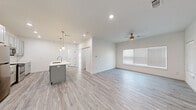 Located at 1506 Powell St in Springdale, AR, this thoughtfully designed single-story home offers a bright, modern interior with a clean, neutral aesthetic throughout. Light wood-look flooring flows seamlessly across the entire space, complementing the crisp white walls and creating a cohesive, airy feel.

The open-concept kitchen and living area serves as the heart of the home. The kitchen is well-appointed with gray shaker-style cabinetry, a large quartz island with an undermount sink, stainless steel appliances including a refrigerator, range, and microwave, and stylish pendant lighting overhead. A dedicated laundry room provides added convenience with a full-size washer and dryer included.

The spacious bedroom features vaulted ceilings, a ceiling fan with a brushed gold finish, and multiple windows that invite generous natural light from multiple directions. A closet and access to the full bathroom complete the private quarters.

The bathroom is finished with the same gray cabinetry found in the kitchen, paired with a white quartz vanity top, a tub/shower combo, and wood-look flooring that ties the space together. Recessed lighting and ceiling fans throughout the home add both functionality and a polished, contemporary feel to this well-equipped Springdale residence.