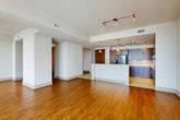 Located on the 17th floor of a high-rise in the heart of Seattle, this 2-bedroom, 3-bathroom residence with a den offers a well-appointed urban living experience. The open-concept layout seamlessly connects the living room, dining area, and kitchen, all anchored by rich hardwood flooring and track lighting. Floor-to-ceiling windows flood the living spaces with natural light and frame sweeping views of the Seattle skyline and surrounding cityscape.

The kitchen is finished with dark wood cabinetry, granite countertops, stone tile flooring, and stainless steel appliances, including a French door refrigerator and built-in microwave. A central island provides additional prep and serving space.

Both bedrooms are carpeted and receive generous natural light through large windows with impressive city views. The spacious primary bedroom includes a ceiling fan and access to a well-organized walk-in closet featuring built-in shelving, hanging rods, and a built-in dresser. The bathrooms are finished with marble-style tile flooring for a clean, refined aesthetic.

A versatile den with hardwood flooring offers additional flexible space. With five closets total and a thoughtful layout, this high-rise residence delivers both comfort and functionality in a prime downtown Seattle location.