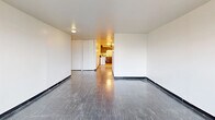 Located at 6253 South Michigan Avenue in Chicago, IL, this single-floor, three-bedroom, one-bathroom unit offers a functional and straightforward layout. The combined living and dining room serves as the central gathering space, featuring dark tile flooring and clean white walls that create a neutral, versatile backdrop. An adjacent kitchen is outfitted with warm wood cabinetry and includes a refrigerator, offering a compact yet practical cooking area.

The three bedrooms are well-proportioned, with the primary bedroom providing a comfortable amount of space. Each bedroom benefits from large, multi-pane windows with horizontal blinds that invite generous natural light and offer views of the surrounding tree canopy — a standout feature throughout the unit. Several bedrooms include built-in closet storage, and the unit as a whole boasts an impressive six closets, ensuring ample storage for residents.

The bathroom features a clean, fully tiled shower and tub combination with white square tiles and a decorative shower curtain. Dark tile flooring runs consistently through the main living areas, while the overall palette of bright white walls and neutral tones lends the space a clean, move-in ready feel. A hallway connects the rooms efficiently, contributing to the unit's organized and practical flow.