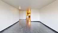 Located at 6253 South Michigan Avenue in Chicago, IL, this single-floor, three-bedroom, one-bathroom unit offers a functional and straightforward layout. The combined living and dining room serves as the central gathering space, featuring dark tile flooring and clean white walls that create a neutral, versatile backdrop. An adjacent kitchen is outfitted with warm wood cabinetry and includes a refrigerator, offering a compact yet practical cooking area.

The three bedrooms are well-proportioned, with the primary bedroom providing a comfortable amount of space. Each bedroom benefits from large, multi-pane windows with horizontal blinds that invite generous natural light and offer views of the surrounding tree canopy — a standout feature throughout the unit. Several bedrooms include built-in closet storage, and the unit as a whole boasts an impressive six closets, ensuring ample storage for residents.

The bathroom features a clean, fully tiled shower and tub combination with white square tiles and a decorative shower curtain. Dark tile flooring runs consistently through the main living areas, while the overall palette of bright white walls and neutral tones lends the space a clean, move-in ready feel. A hallway connects the rooms efficiently, contributing to the unit's organized and practical flow.