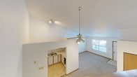 Located at 700 Township Road 179 in Bellefontaine, Ohio, this two-floor residence offers a practical and well-organized layout across two levels. The main floor features a carpeted living area with tile flooring at the entry, bathed in natural light through a front-facing window with blinds. The adjacent kitchen is efficiently designed with white cabinetry framed in oak trim, a double-basin stainless steel sink, ample counter space, and a range, all set on tile flooring. A staircase with a wooden handrail connects the main floor to the upper level. A dedicated laundry closet with washer hookups and utility infrastructure is also found on this level. The full bathroom features a single-sink vanity with a large mirror, a tub-shower combination, and tile flooring. Upstairs, the bedrooms are carpeted and showcase vaulted ceilings that lend a sense of openness and volume, with windows providing natural light. One bedroom includes a ceiling fan and closet access, while another features dual doorways and its own vaulted ceiling. Textured ceilings are consistent throughout the home, complemented by warm wood-tone trim and doors, contributing to a cohesive, understated aesthetic throughout the space.