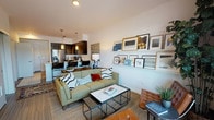 Located along East Lake Sammamish Parkway in Redmond, Washington, this single-floor residence offers a well-appointed, open-concept layout designed for comfortable modern living. The living area serves as the heart of the home, featuring light hardwood-style flooring, a curated gallery wall shelf, and a seamless flow into the kitchen and dining space. Large sliding glass doors open onto a private balcony, where sweeping views of the surrounding Pacific Northwest landscape create a striking backdrop.

The kitchen is outfitted with dark espresso cabinetry, white quartz countertops, a classic subway tile backsplash, and a full suite of stainless steel appliances, including a range, microwave, and refrigerator. Pendant lighting adds warmth to the space.

The bedroom is a comfortable retreat with plush carpeting, a window framing outdoor views, and ample room for furnishings. The bathroom features a full tub-shower combination with clean white tile surround, dark cabinetry with a white countertop vanity, and wood-look tile flooring. An in-unit laundry area adds everyday convenience. Overall, the residence offers a clean, contemporary aesthetic with functional design throughout.