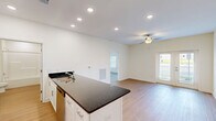 Located at 6801 W Friendly Ave in Greensboro, NC, this well-appointed one-bedroom, one-bathroom unit offers a thoughtfully designed layout across a single floor. The open kitchen is a standout feature, showcasing dark granite countertops, crisp white shaker cabinetry, and a full suite of stainless steel appliances including a refrigerator, range, microwave, and dishwasher. Recessed lighting illuminates the space, while light hardwood-style flooring runs throughout the main living and kitchen areas, adding warmth and continuity. The bedroom is generously sized, finished with plush carpeting, a ceiling fan with lighting, and multiple windows that invite natural light and views of the surrounding exterior. A dedicated walk-in closet off the bedroom provides ample storage with built-in wire shelving. The bathroom is clean and functional, featuring a full tub/shower combination, white cabinetry with granite countertops, and durable hardwood-style flooring. Neutral wall tones throughout the unit create a bright, move-in-ready atmosphere that offers a versatile canvas for personalization. The overall design balances modern finishes with practical functionality, making it a comfortable and attractive living space.