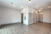 Located at 78 Drake St in Charleston, South Carolina's historic 29403 zip code, this single-floor unit offers a clean, modern design with an open and airy layout. Light wood-look flooring flows consistently throughout the space, complementing the bright, neutral color palette on the walls and ceilings.

The kitchen is a standout feature, equipped with white shaker-style cabinetry, granite countertops, a classic subway tile backsplash, and a full suite of stainless steel appliances including a refrigerator, electric range, over-the-range microwave, dishwasher, and double-basin sink. Recessed lighting in the main living area keeps the space well-lit and open.

The living area is generously proportioned and benefits from natural light, highlighted by a set of French doors topped with a transom window that open to an outdoor area — ideal for enjoying Charleston's mild climate. A ceiling fan adds comfort to both the living space and additional rooms.

The bathroom is finished with a gray vanity topped with granite, a framed mirror, matte black hardware accents, and a tiled shower-tub combination. The overall design balances contemporary finishes with functional living, making this a well-appointed space in one of Charleston's sought-after neighborhoods.