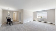 Located at 139 Normal Ave in Kutztown, PA, this 2-bedroom, 1-bathroom residence offers a practical and comfortable single-floor layout. The spacious living room features soft wall-to-wall carpeting, crisp white walls, and a large window that draws in natural light while offering views of the surrounding neighborhood. Baseboard heating and a wall-mounted AC unit provide year-round climate control throughout the home.

The hallway connects the living area to two well-sized bedrooms, each carpeted and painted in neutral tones. The primary bedroom is generously proportioned, featuring multiple windows with blinds that allow for ample natural light, along with individual climate control. The second bedroom is equally comfortable, with its own window and a closet for storage.

The kitchen is a standout feature, boasting dark cabinetry with modern hardware, light granite-style countertops, a white subway tile backsplash, light wood-look flooring, and a gas range with a built-in microwave. A window over the sink adds natural light to the functional galley-style layout.

The bathroom is finished with floor-to-ceiling neutral stone-look tile surrounding a full bathtub and shower combination, lending a clean and polished aesthetic. A dedicated closet rounds out the home's storage options.
