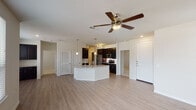 This single-story residence in Conroe, Texas offers a thoughtfully designed open-concept floor plan that seamlessly connects the living, dining, and kitchen areas. Light wood-style flooring extends throughout the main living spaces, complemented by neutral walls and a ceiling fan with integrated lighting that anchors the generous living area.

The kitchen is a standout feature, showcasing dark espresso cabinetry with sleek hardware, granite countertops, a white subway tile backsplash, and a full suite of stainless steel appliances including a refrigerator, range, and over-the-range microwave. A curved kitchen island with a granite surface and undermount sink provides additional workspace and seating, while pendant lighting adds a polished touch overhead.

Both bathrooms feature granite-topped vanities with dark cabinetry. The primary bathroom includes a soaking tub with tile surround, while the secondary bathroom offers a glass-enclosed walk-in shower with tile walls. A walk-in closet with multi-tier shelving and hanging rods provides ample storage off the primary suite. Bedrooms are carpeted for comfort.

A dedicated laundry closet houses a full-size washer and dryer, adding everyday convenience to this well-finished Conroe residence.