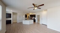 This single-story residence in Conroe, Texas offers a thoughtfully designed open-concept floor plan that seamlessly connects the living, dining, and kitchen areas. Light wood-style flooring extends throughout the main living spaces, complemented by neutral walls and a ceiling fan with integrated lighting that anchors the generous living area.

The kitchen is a standout feature, showcasing dark espresso cabinetry with sleek hardware, granite countertops, a white subway tile backsplash, and a full suite of stainless steel appliances including a refrigerator, range, and over-the-range microwave. A curved kitchen island with a granite surface and undermount sink provides additional workspace and seating, while pendant lighting adds a polished touch overhead.

Both bathrooms feature granite-topped vanities with dark cabinetry. The primary bathroom includes a soaking tub with tile surround, while the secondary bathroom offers a glass-enclosed walk-in shower with tile walls. A walk-in closet with multi-tier shelving and hanging rods provides ample storage off the primary suite. Bedrooms are carpeted for comfort.

A dedicated laundry closet houses a full-size washer and dryer, adding everyday convenience to this well-finished Conroe residence.
