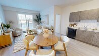 Located at 7 Belvedere Avenue SE in Calgary, this 2-bedroom, 2-bathroom unit is designed with a clean, modern aesthetic and a neutral colour palette that creates a bright and welcoming atmosphere throughout. The open-concept living, dining, and kitchen area forms the heart of the home, featuring light-toned laminate flooring, white tile backsplash, and textured wood-grain cabinetry paired with black and stainless steel appliances, including a full-size refrigerator and dishwasher. A sliding glass door in the living room fills the space with natural light and provides outdoor views. The primary bedroom is a comfortable retreat with a window, light flooring, and ample wall space. The second bedroom mirrors the same bright, airy feel. Both bathrooms are well-appointed; one features a glass-enclosed stand-up shower with white tile surround and a vanity with stone-finish countertop. A dedicated laundry room houses a stacked washer and dryer unit alongside built-in wire shelving for added storage. A separate closet and entrance hallway round out the practical layout, making this unit a functional and well-organized home in a growing Calgary community.