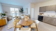 Located at 7 Belvedere Avenue SE in Calgary, this 2-bedroom, 2-bathroom unit is designed with a clean, modern aesthetic and a neutral colour palette that creates a bright and welcoming atmosphere throughout. The open-concept living, dining, and kitchen area forms the heart of the home, featuring light-toned laminate flooring, white tile backsplash, and textured wood-grain cabinetry paired with black and stainless steel appliances, including a full-size refrigerator and dishwasher. A sliding glass door in the living room fills the space with natural light and provides outdoor views. The primary bedroom is a comfortable retreat with a window, light flooring, and ample wall space. The second bedroom mirrors the same bright, airy feel. Both bathrooms are well-appointed; one features a glass-enclosed stand-up shower with white tile surround and a vanity with stone-finish countertop. A dedicated laundry room houses a stacked washer and dryer unit alongside built-in wire shelving for added storage. A separate closet and entrance hallway round out the practical layout, making this unit a functional and well-organized home in a growing Calgary community.