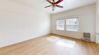 Located at 463 Hartford Ave in Los Angeles, CA, this one-bedroom, one-bathroom unit offers a compact and efficiently designed single-floor layout. Light wood flooring runs throughout, lending a clean and cohesive look to the space.

The spacious primary bedroom is the largest room in the unit, featuring bright white walls, a ceiling fan with light fixture, and a large window with blinds that invites natural light and offers outdoor views. A closet with mirrored sliding doors provides convenient storage.

The kitchen is thoughtfully arranged with warm honey-toned wood cabinetry, granite-style countertops, a gas range, a refrigerator, and a single-basin sink beneath a window fitted with blinds. Natural light filters in, making the kitchen feel open despite its efficient footprint.

The bathroom features a tiled shower and tub combination enclosed by a curved glass door. White marble-style tiles with a decorative mosaic accent border create a clean, polished aesthetic. The hallway connects the rooms, completing the straightforward and functional floor plan.

Overall, the unit offers a bright, clean living environment with practical finishes, making it a well-appointed space in the heart of Los Angeles.