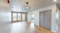 Located at 5053 Shelby Ave in Rapid City, South Dakota, this single-story, 3-bedroom, 3-bathroom home offers a practical and well-designed layout. The open-concept kitchen and living area serves as the heart of the home, featuring light hardwood-style flooring, recessed lighting, and neutral taupe-toned walls. The kitchen is equipped with gray cabinetry, white countertops, a stainless-style sink, and black appliances including a refrigerator, dishwasher, and range. Large windows with blinds and a glass-panel entry door fill the living area with natural light and provide outdoor views. Each of the three bedrooms is carpeted with soft neutral tones and includes windows that bring in additional daylight. The primary bedroom features a dedicated walk-in closet outfitted with wire shelving for organized storage. The three bathrooms include both a walk-in shower with chrome fixtures and a separate shower/tub combination, with tile-style flooring in each. A dedicated laundry room accommodates a full-size washer and dryer side by side, complete with overhead wire shelving. Clean finishes, consistent neutral tones, and a functional floor plan define the overall character of this Rapid City home.