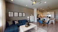 Located at 12500 SW 175th Ave in Beaverton, Oregon, this thoughtfully designed single-floor residence blends modern aesthetics with functional living. The open-concept layout seamlessly connects the living, dining, and kitchen areas, creating a cohesive and inviting atmosphere throughout.

The living room is bright and airy, featuring large windows with sheer curtains that flood the space with natural light and frame views of the surrounding Beaverton skyline. A ceiling fan adds comfort, while a door leads directly to a private balcony — ideal for enjoying the outdoors. The living area flows effortlessly into the dining space, which benefits from pendant lighting overhead.

The kitchen is well-appointed with white cabinetry extending to the ceiling, a neutral tile backsplash with under-cabinet lighting, stone countertops, and a full suite of stainless steel appliances including a French door refrigerator, range, microwave, and dishwasher. A bar-height island provides additional seating and prep space.

The bedroom is a serene retreat with plush carpeting, a large window offering outdoor views, and direct access to a bathroom featuring a walk-in closet with built-in wire shelving. Throughout the residence, light wood-tone flooring unifies the common areas, contributing to the clean, contemporary character of the home.