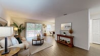 Located at 5001 SW 20th St in Ocala, Florida, this single-floor residence offers a well-designed layout that balances comfort and functionality. The living area features warm wood-look flooring, neutral walls, and a welcoming atmosphere, with a large sliding glass door that floods the space with natural light and provides direct access to a private outdoor patio overlooking lush greenery. The open flow connects the living area seamlessly to the dining space, which is illuminated by a classic chandelier and accompanied by its own sliding glass door for additional outdoor access and natural light.

The galley-style kitchen is efficiently organized with white cabinetry, wood-trimmed shelving, and full appliances including a range and refrigerator, offering a clean and practical cooking environment. The bedrooms are carpeted and generously sized, each with bright windows that invite natural light and provide a tranquil retreat. The primary bedroom includes a private en-suite access area, adding a layer of convenience.

Throughout the residence, consistent wood-look flooring in the main living spaces and soft carpet in the bedrooms create a cohesive and inviting aesthetic. The overall ambiance is light, airy, and thoughtfully appointed, making this Ocala home a comfortable and functional living space.