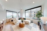 Located in Midtown Atlanta, this sophisticated 2-bedroom, 2-bathroom residence offers a refined open-concept layout bathed in natural light. The living and dining areas are anchored by expansive floor-to-ceiling windows framed in sleek black trim, delivering sweeping views of the Atlanta skyline and lush treetops below. Light hardwood flooring flows throughout, complementing the bright, neutral palette of the space.

The kitchen is thoughtfully designed with white shaker cabinetry, matte black hardware, gray quartz countertops, a subway tile backsplash, and a gas range — combining style with everyday functionality. The dining area, wrapped in corner windows, creates an airy and inviting setting with panoramic views as a backdrop.

The primary bedroom features a warm terracotta accent wall and direct access to a well-appointed walk-in closet. Its en-suite bathroom includes a frameless glass walk-in shower clad in marble-style tile, matte black fixtures, and clean white cabinetry with quartz countertops. The second bedroom offers versatility, having been utilized as a home office, and is served by a second full bathroom of equally high finish quality.

Additional conveniences include in-unit laundry, a utility room, and multiple closets providing generous storage throughout.