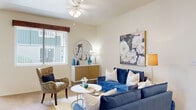 This single-floor residence offers a thoughtfully designed layout with a warm, neutral color palette that creates a welcoming atmosphere throughout. The living room serves as the heart of the home, featuring plush carpeting, a ceiling fan, and a large window with vertical blinds that allows natural light to fill the space. The room offers generous proportions, ideal for comfortable everyday living and entertaining.

Adjacent to the living area, the dining nook provides an intimate setting for meals, benefiting from its own window and direct access to an exterior door, bringing in additional natural light. The galley-style kitchen is efficiently organized, featuring light wood cabinetry, tile flooring, a skylight overhead, a double sink, and white appliances including a range, microwave, and dishwasher.

The unit includes two bedrooms, each with soft carpeting and ample natural light from large windows. The primary bedroom features views of the surrounding greenery, while the second bedroom offers a calm, restful retreat. A full bathroom serves the unit, complete with a vanity featuring light wood cabinetry, a wide mirror, and tile flooring that coordinates with the kitchen. An additional flexible space with recessed lighting and access to closets rounds out this well-planned home.