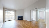 Located at 11755 Norbourne Dr in Forest Park, Ohio, this two-bedroom, one-bathroom unit offers a well-organized single-floor layout with a variety of functional and attractive features throughout. The living room immediately impresses with its vaulted ceiling, warm hardwood flooring, and a classic tile-surround fireplace, creating a welcoming central gathering space. A sliding glass door fills the room with natural light and opens to a private balcony overlooking the community courtyard and parking area. The kitchen is accessible directly from the living area, featuring dark cabinetry and black appliances. Both bedrooms are carpeted and comfortably sized. The primary bedroom includes a ceiling fan, direct access to the full bathroom, and a private balcony with sliding glass door. The second bedroom features a mirrored sliding-door closet and a window with neighborhood views. The shared bathroom offers hardwood flooring, a dark wood vanity with a generous countertop, and a full tub-shower combination. A dedicated closet provides additional storage. Neutral gray and beige tones throughout the unit contribute to a clean, move-in-ready aesthetic that suits a variety of décor styles.