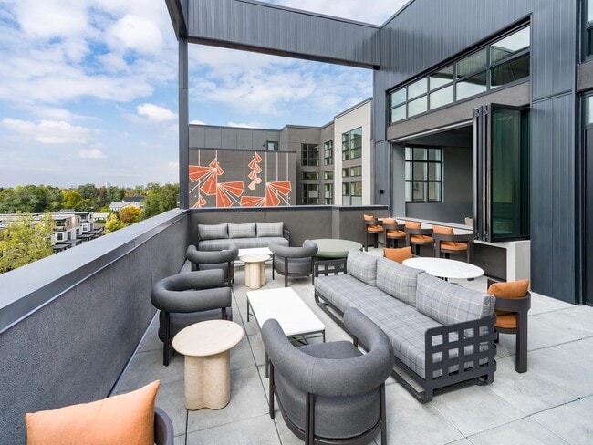 Una acogedora terraza en Modera University Park, diseñada para reuniones relajadas con vistas al vecindario y fácil acceso al University Park que se encuentra abajo. - Modera University Park