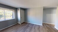 Located at 720 Brittany Square in Grayslake, IL, this single-floor unit offers a well-organized layout with a cohesive, modern aesthetic. The interior is finished with a cool gray color palette and crisp white trim throughout, creating a clean and contemporary feel.

The kitchen is a functional highlight of the space, featuring white shaker-style cabinetry extending to the ceiling for ample storage, a neutral-toned countertop, a stainless steel sink with a modern faucet, and a full suite of stainless steel appliances including a refrigerator and dishwasher. A track light fixture illuminates the space, and light wood-style flooring adds warmth underfoot.

The main living areas are finished with durable gray wood-style laminate flooring, offering a polished, low-maintenance surface. Windows dressed with horizontal blinds allow natural light to filter in. The bedroom features soft wall-to-wall carpeting and a closet, providing a comfortable and practical retreat. An additional room with laminate flooring and a dedicated door offers flexible use as a bedroom or office.

The bathroom is neatly appointed with a full tub and shower combination, chrome fixtures, and coordinating gray walls. The overall layout, visible in the dollhouse view, reflects an efficient and practical floor plan suited for everyday living.