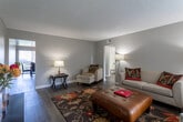 Located at 1790 W Arrow Rte in Upland, California, this single-floor residence offers a well-organized and functional layout throughout. The living room is a welcoming space featuring dark hardwood-style flooring, neutral gray walls, a textured ceiling, and a large window fitted with vertical blinds that allow generous natural light to fill the room. The kitchen is outfitted with white cabinetry, light countertops, a gas range, a dishwasher, and a peninsula that opens toward the adjacent dining area, which includes a ceiling fan. Dark hardwood-style flooring continues through the kitchen and dining space, creating a cohesive look. The bedroom is carpeted and spacious, with a window providing natural light and two closets offering ample storage. The textured ceiling is consistent throughout the unit. Two bathrooms serve the residence — one features a shower/tub combination, white vanity with a wide mirror, and hardwood-style flooring, while the second bathroom is similarly appointed with a clean, bright aesthetic. Clean white walls and consistent finishes throughout the home contribute to a tidy and comfortable atmosphere suited for everyday living.