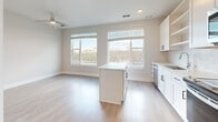 Located at 341 Great Circle Rd in Nashville, TN, this single-floor residence offers a clean, modern aesthetic with thoughtfully selected finishes throughout. The open-concept kitchen and living area serves as the heart of the space, featuring white shaker-style cabinetry, a central island, stainless steel appliances including a refrigerator, range, and microwave, and a marble-inspired tile backsplash. Light wood-style flooring runs seamlessly across the main living areas, complementing the bright, neutral color palette. Large windows flood the space with natural light and provide views of the surrounding Nashville landscape, enhancing the airy, open ambiance. A ceiling fan adds both comfort and a subtle design element to the living area. The bedroom is appointed with plush carpeting and features a spacious walk-in closet outfitted with wire shelving and double doors, offering generous storage. The bathroom is finished to a high standard, showcasing white cabinetry with matte black hardware, a quartz countertop, an undermount sink, a backlit vanity mirror, and a glass-enclosed walk-in shower with subway tile surround. Every detail of this residence reflects a commitment to contemporary design and functional living.