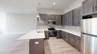 Located at 70 Church St in Flemington, NJ, this well-appointed one-bedroom, one-bathroom unit offers a thoughtfully designed single-floor layout with generous living space. Light wood-style flooring flows throughout, complementing the clean, neutral palette that gives the home a bright and airy feel.

The open-concept kitchen and living area serves as the heart of the unit. The kitchen is outfitted with rich dark-toned shaker cabinetry, quartz countertops, stainless steel appliances, and a peninsula with a built-in sink — all illuminated by stylish pendant lighting. The adjacent living area is expansive, featuring large windows that draw in abundant natural light and offer views of the surrounding neighborhood, along with a wall-mounted split HVAC unit for year-round comfort.

The bedroom is a comfortable retreat, complete with a double-door closet and a wall-mounted HVAC unit. With four closets total throughout the unit, storage is plentiful. The bathroom features a full tub-shower combo finished with white subway-style tile and sleek matte black fixtures. A dedicated laundry area and a well-proportioned hallway round out this efficiently planned home, making it an ideal space for modern everyday living.