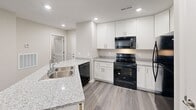 Located at 2715 Statesville Blvd in Salisbury, NC, this single-story, three-bedroom, two-bathroom home offers a well-designed layout with modern finishes throughout. Wood-look plank flooring flows seamlessly across all living spaces, complemented by neutral-toned walls and clean white trim that create a bright, cohesive aesthetic.

The open-concept kitchen and living area serves as the heart of the home. The kitchen features white shaker-style cabinetry, granite-look countertops, a peninsula with an integrated sink, recessed lighting, and black appliances. The living room connects directly to the kitchen, with access to a private outdoor area through elegant French doors that invite natural light.

The spacious primary bedroom offers a generous walk-in closet outfitted with double hanging rods and built-in shelving, providing ample storage. Two additional bedrooms share the well-appointed second bathroom, while the primary suite is served by its own bathroom. Both bathrooms are finished with white vanities, granite-look countertops, wall-mounted lighting, and full tub-shower combinations.

A dedicated in-unit laundry room accommodates a full-size washer and dryer and includes an overhead shelf for added storage. The home's clean, contemporary design and practical layout make it a comfortable and functional living space.