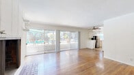 Located in the heart of Studio City, this 2-bedroom, 2-bathroom unit offers a well-planned single-floor layout with a clean, functional design. The living room is a standout space, featuring warm hardwood floors, a white-brick fireplace, and expansive sliding glass doors that open to a patio with direct views of the pool area, filling the room with natural light and a seamless indoor-outdoor connection. The kitchen is thoughtfully designed with white cabinetry, warm wood-toned countertops, stainless steel dishwasher, and a full suite of appliances, including a gas range and refrigerator. Open shelving and a pass-through connect the kitchen to the living area, enhancing the open feel. Both bedrooms feature hardwood floors and natural light from windows with garden views. The primary bedroom includes a ceiling fan and sliding closet doors, while the second bedroom also has a ceiling fan and ample space. The two bathrooms each have distinct character: one features classic white subway tile, a soaking tub, and a bright window, while the other offers a walk-in shower, decorative stone-tile flooring, and a white vanity. Hallways provide practical connectivity throughout the unit.