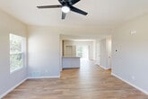 Located at 315 Dry Brook Rd in Wentzville, MO, this three-bedroom, three-bathroom home is thoughtfully laid out across three floors. The ground level houses an attached garage with an automatic opener, a dedicated laundry room with washer and dryer, and utility spaces. The main living floor features an open-concept kitchen and living area bathed in natural light from multiple windows. The kitchen is well-appointed with white shaker-style cabinetry, granite countertops, stainless steel appliances including a range, microwave, and dishwasher, plus a black refrigerator. Warm hardwood-style flooring flows throughout the main living areas, complemented by neutral-toned walls and ceiling fans. A pantry adds convenient storage adjacent to the kitchen. The upper floor hosts all three bedrooms, each featuring ceiling fans, hardwood-style flooring, and ample closet space — including a walk-in closet with wire shelving in the primary bedroom. Three full bathrooms serve the home, including one with a soaking tub and tiled surround. A hallway connects the upper-level rooms, with two staircases providing easy access between floors. The home offers a clean, modern aesthetic with a functional and spacious layout ideal for everyday living.