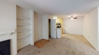 This single-floor residence offers a practical and comfortable layout across two bedrooms and two full bathrooms. The living room serves as a central gathering space, featuring plush carpeting, a fireplace flanked by built-in shelving, and a wall-mounted mini-split unit for climate control. A sliding glass door opens to a private balcony, allowing natural light to fill the room and providing outdoor views of surrounding greenery.

Adjacent to the living area, the dining space includes a ceiling fan and connects seamlessly to the kitchen. The kitchen is equipped with light wood cabinetry, stainless steel appliances including a refrigerator, range, and microwave, light countertops, and wood-style flooring, offering a functional workspace.

Both bedrooms are carpeted and feature windows with vertical blinds that frame outdoor foliage views. Baseboard heaters are present in each bedroom, and the rooms provide comfortable proportions for furnishing.

The two bathrooms are finished with light wood-style flooring, wood-toned vanity cabinetry, and speckled countertops. Each bathroom includes a tub-shower combination with sliding glass doors and chrome fixtures, maintaining a clean, neutral aesthetic throughout.