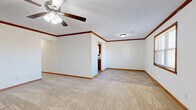 Located at 2460 Clearwater Ct in Bowling Green, Kentucky, this single-story, 3-bedroom, 2-bathroom home offers a practical and comfortable layout throughout. Warm wood trim and baseboards are consistent across every room, lending a cohesive, classic character to the interior. The living room features plush carpeting, a ceiling fan with light fixture, and natural light from a window, creating a welcoming common area. The kitchen is equipped with rich oak cabinetry, light granite-style countertops, a double stainless steel sink, a window above the counter, and tile flooring — with space for a refrigerator and dishwasher. The generously sized primary bedroom showcases crown molding, a ceiling fan, and a transition from carpet to tile that connects to a private en-suite bathroom. Additional bedrooms are carpeted and include ceiling fans and windows that bring in natural light. The bathrooms feature oak vanities with solid countertops and tile flooring. A dedicated laundry room provides overhead cabinetry, washer and dryer hookups, and tile flooring. The attached garage offers additional utility space with interior access. Throughout the home, neutral wall tones and consistent wood accents create a clean, move-in ready atmosphere.