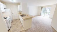 This single-story unit offers three bedrooms and two full bathrooms across a practical, well-organized floor plan. The kitchen is designed in a galley style with white cabinetry lining both sides, light countertops, a gas range, refrigerator, and a double sink. A peninsula extends from the kitchen into the living area, providing additional counter space and a natural division between the two zones. The living area is carpeted and benefits from natural light via a sliding glass door that opens to an outdoor space.

The bedrooms are carpeted and feature neutral walls with ample natural light. One bedroom includes a walk-in closet outfitted with wire shelving spanning the full perimeter, offering generous storage. Additional bedrooms include standard closets with louvered bi-fold doors and wire rod systems.

The primary bathroom features a vanity with built-in cabinetry, a large mirror with overhead lighting, and direct access to a closet. The second bathroom includes a full tub/shower combination, toilet, and tile flooring. Throughout the unit, tile flooring is used in the kitchen and bathrooms, while carpet covers the living and bedroom areas. A hallway connects the bedrooms, creating a clean, functional layout.