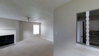 This single-floor residential space offers a clean, functional layout with a neutral color palette throughout. The main living area is finished with wall-to-wall carpet in a warm beige tone, providing a comfortable underfoot feel. Smooth, light gray walls are complemented by crisp white baseboards, creating a simple and cohesive aesthetic. A ceiling fan is centrally positioned beneath a textured popcorn ceiling, offering both air circulation and a practical lighting fixture. Natural light enters through a window fitted with blinds, brightening the room and enhancing its open feel. The room includes standard electrical outlets and light switch panels positioned conveniently along the walls. A partial wall or doorway feature is visible on one side, suggesting a transitional space leading to an adjacent room or hallway. The overall ambiance is understated and move-in ready, with a neutral design that lends itself well to a variety of furnishing styles. The space is well-suited for everyday living, offering a straightforward and comfortable environment throughout its single level.