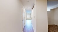 This 780-square-foot apartment at Delancey At Shirlington Village offers a harmonious blend of style and functionality. The open-concept design seamlessly integrates the kitchen and living areas, creating a spacious feel. The kitchen is a highlight, featuring sleek white cabinetry contrasted with dark lower cabinets, stainless steel appliances, and a convenient breakfast bar.

The living room is bathed in natural light from large windows, some extending from floor to ceiling, offering views and potential access to a balcony. The bedroom, measuring 160 square feet, provides ample space and includes a large window for natural illumination.

Two full bathrooms add convenience and luxury, both featuring modern fixtures, large vanities, and a combination of tile and wood-look flooring. Throughout the apartment, warm wood-toned flooring creates a cohesive and inviting atmosphere.

Additional features include recessed lighting, track lighting in some areas, and what appears to be central air conditioning. The apartment's neutral color palette and clean lines contribute to its contemporary aesthetic, making it an ideal canvas for personal styling.